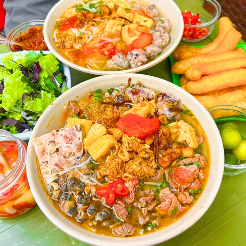 Le Bun riêu Hanoi est une soupe traditionnelle à base de crabe, avec un bouillon acidulé distinctif, offrant une saveur authentique
