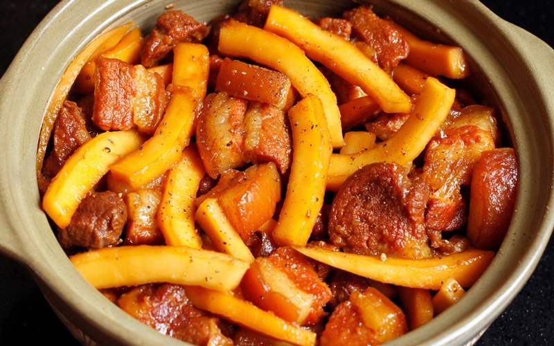 La chair de coco est également mijotée avec le porc, apportant une texture fondante et une saveur douce et onctueuse