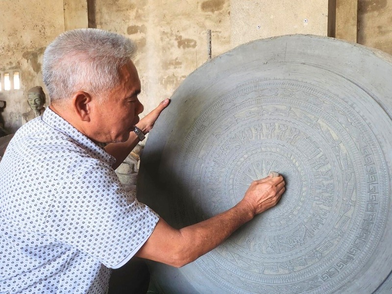 Artisan travaillant un tambour de bronze, héritage du style Dong Son